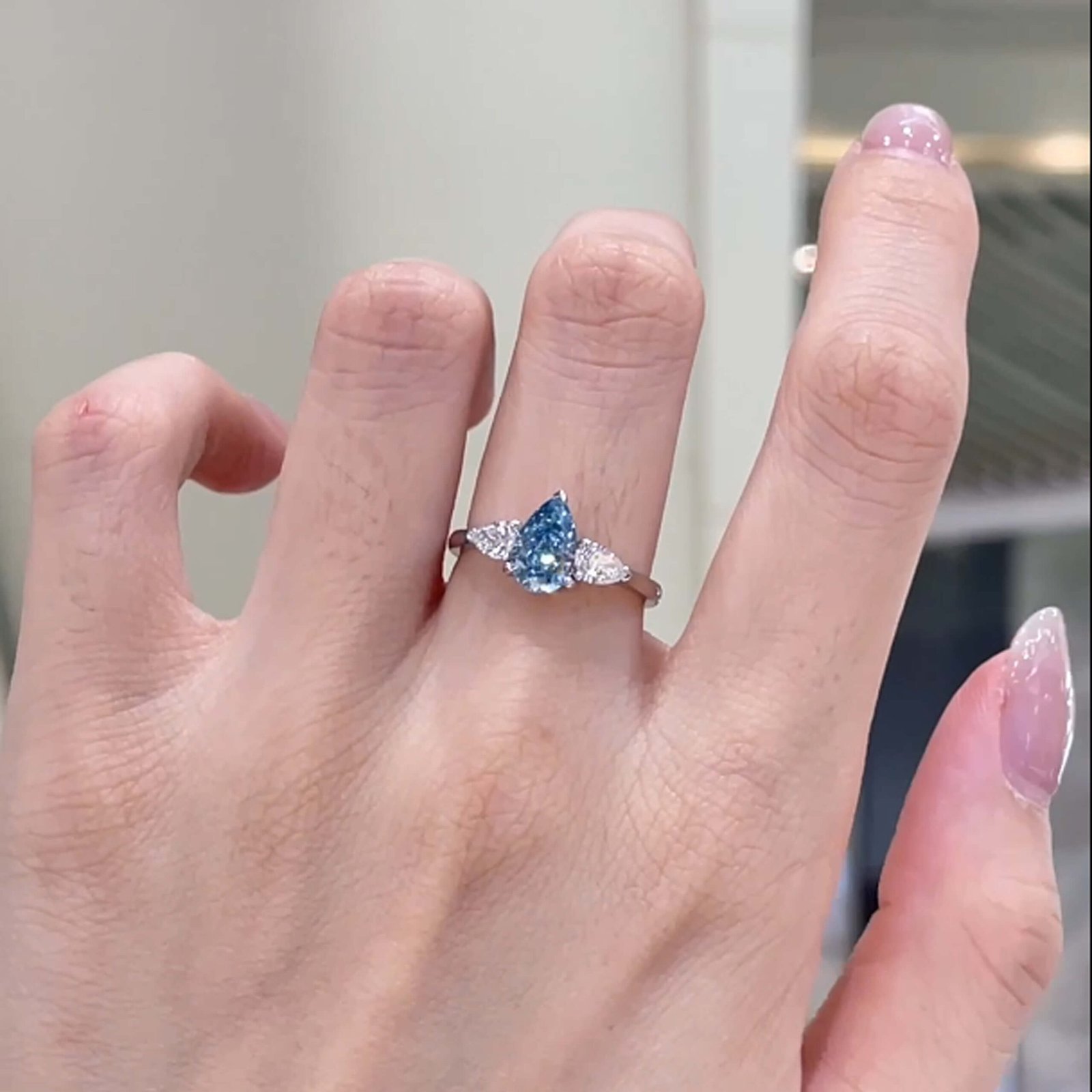 Pear cut lab grown blue diamond three stones engagement ring